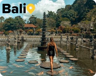 Lady walking on stepping stone near temple in Bali 