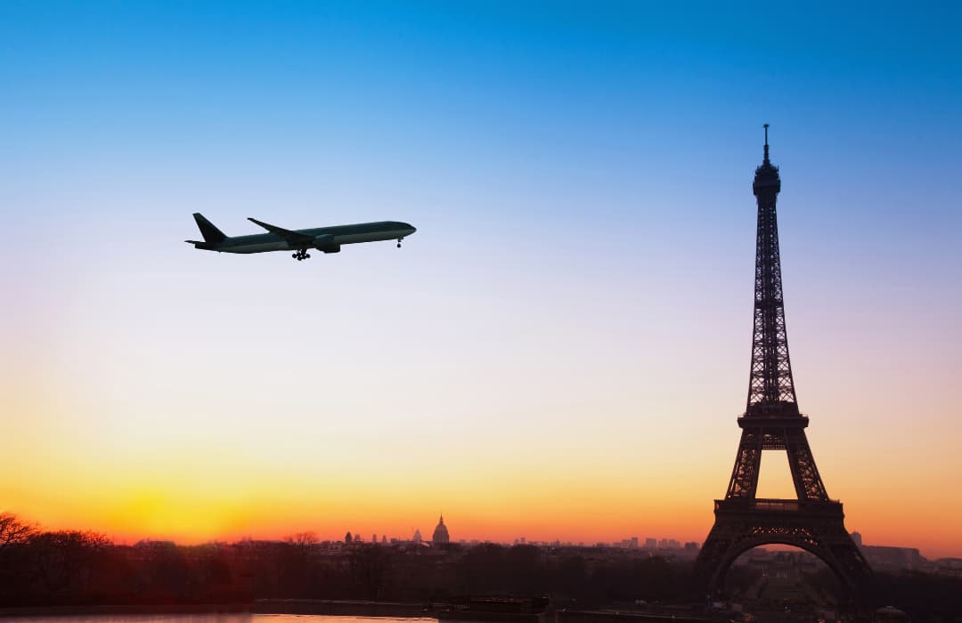 plane-flying-over-effiel-tower-at-sunset