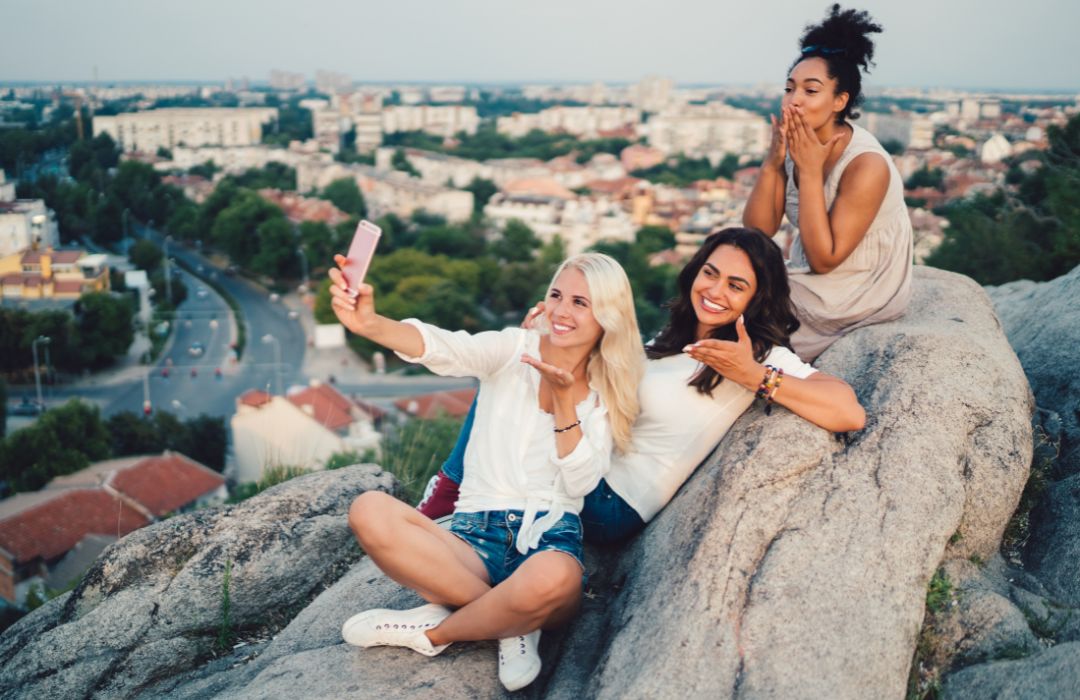 Friends-travelling-sitting-on-a-rock-in-europe